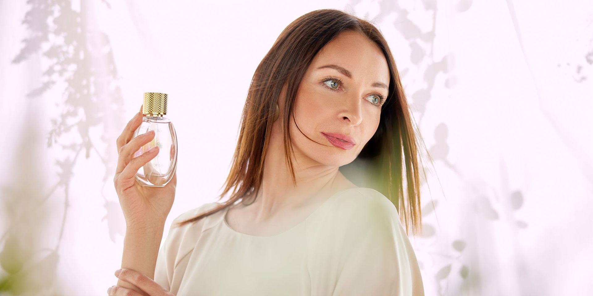 Eine Frau mit einem Parfum in der Hand